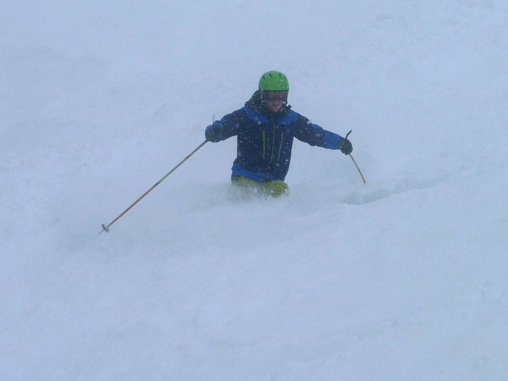 Skieur vu de face dans un mètre de neige poudreuse. Brouillard