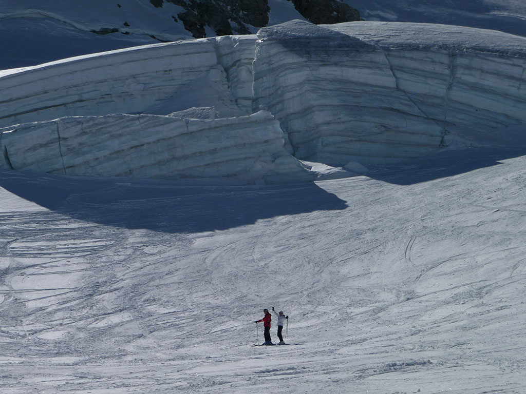 Two skiers posing in front of a huge serac on the Girose glacier